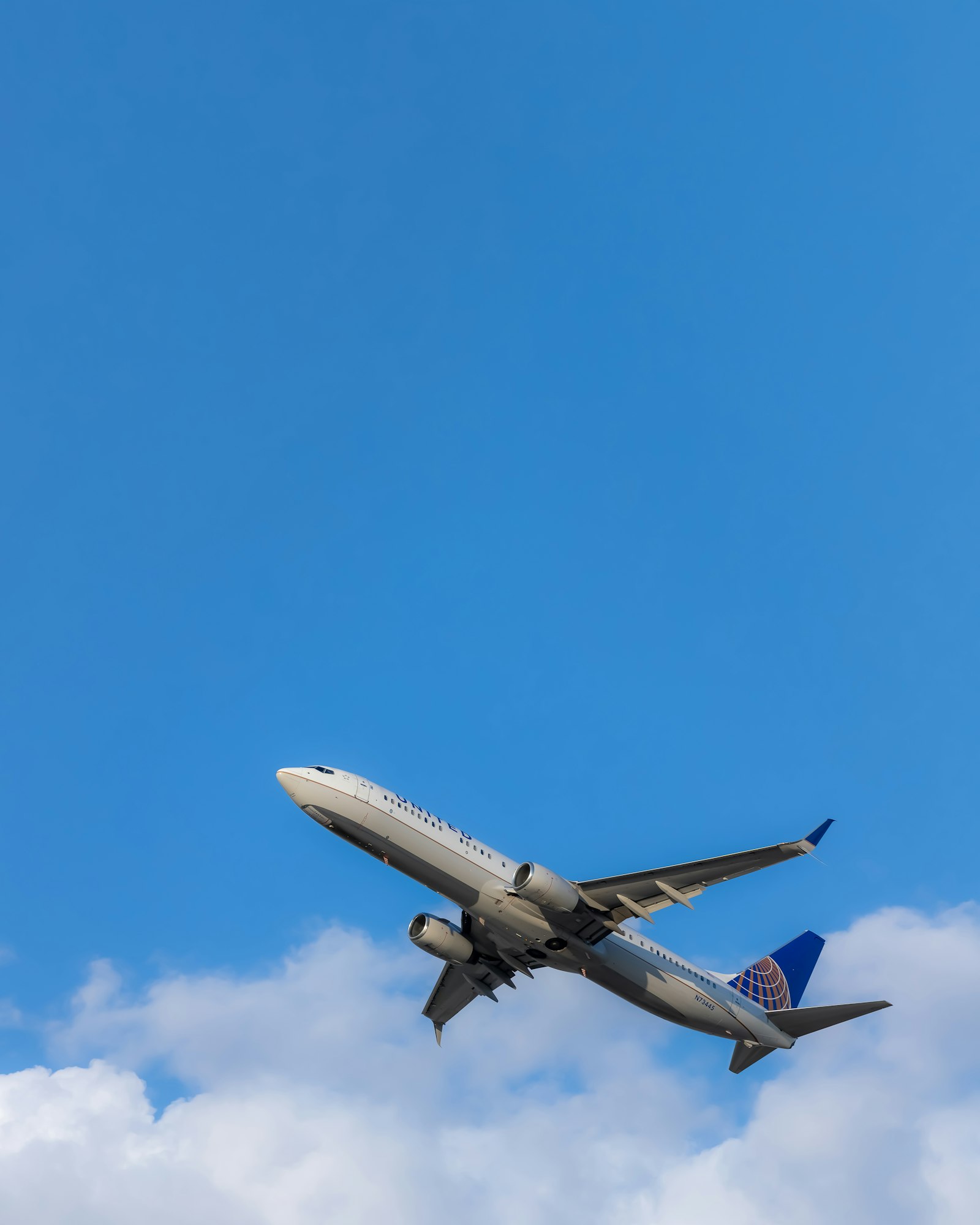 Commercial jet climbing into a blue sky